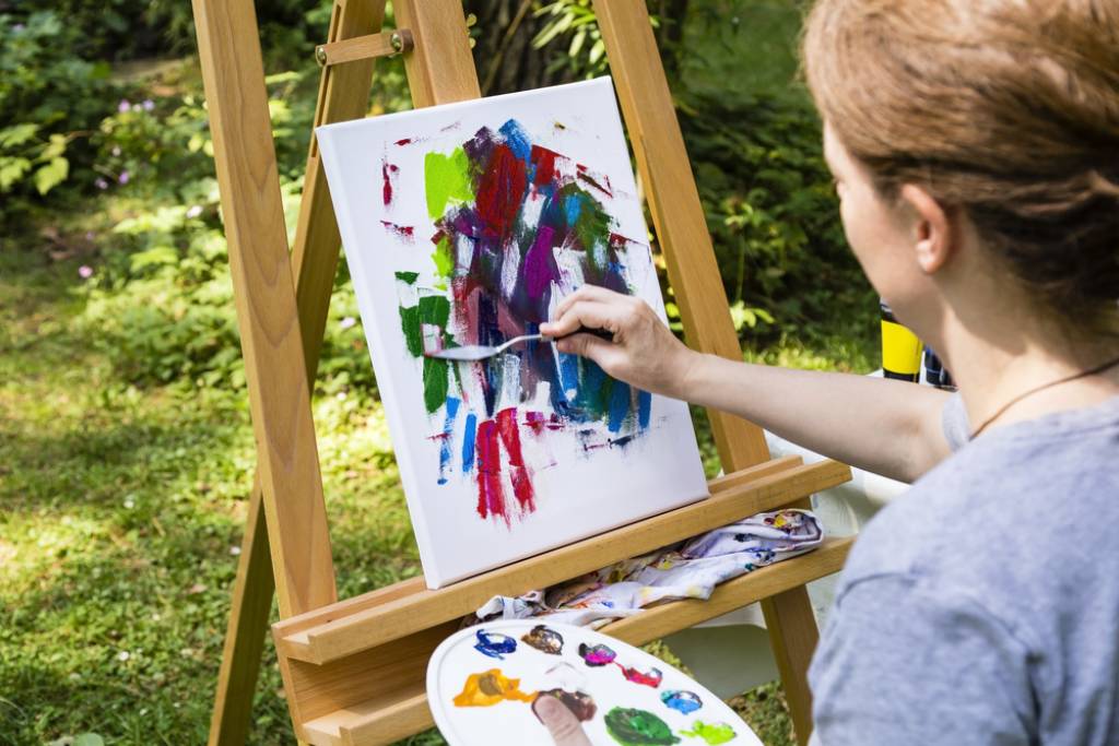 A woman painting on a canvas for art therapy. 