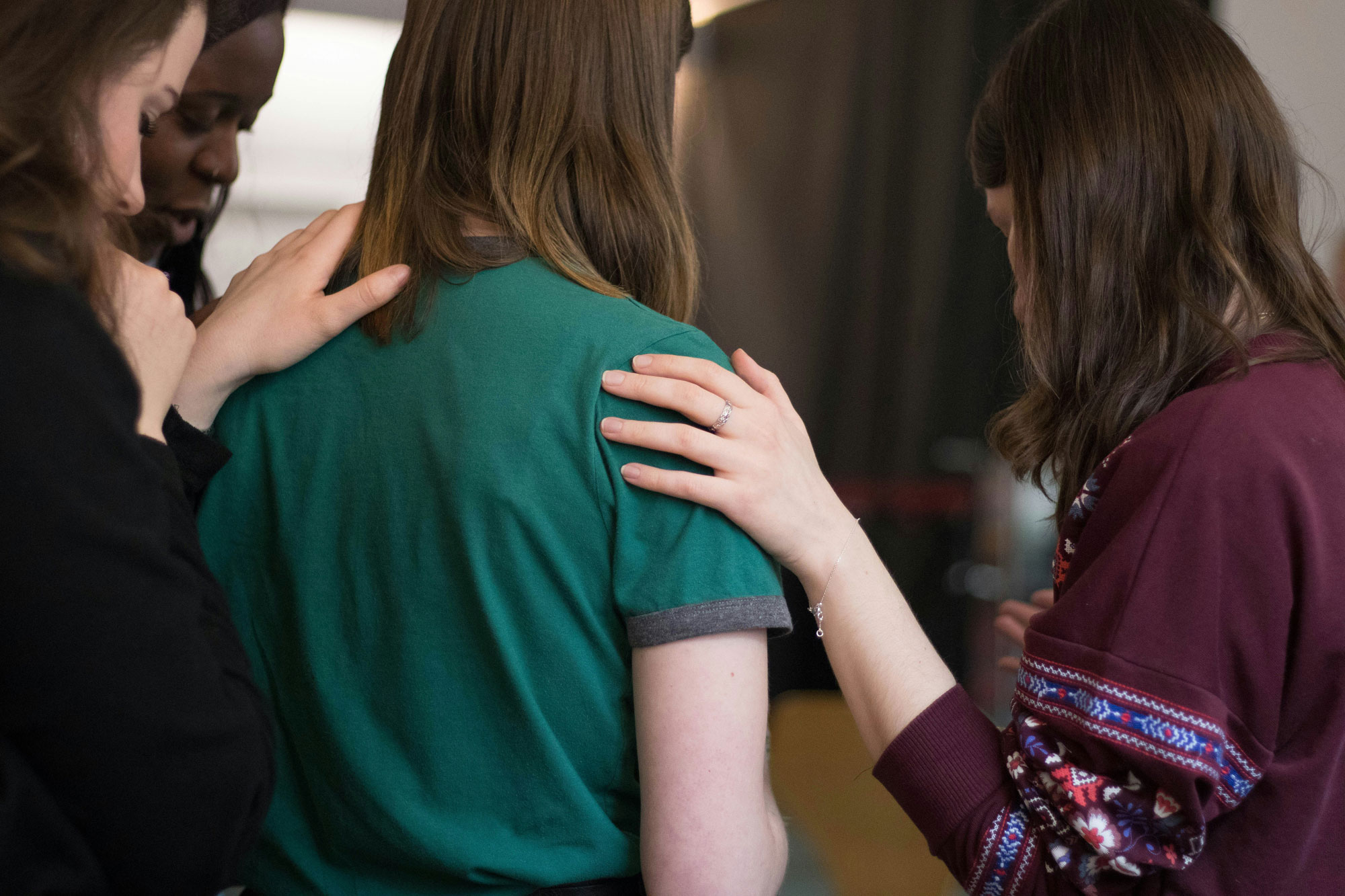 a group of women consoling their friend