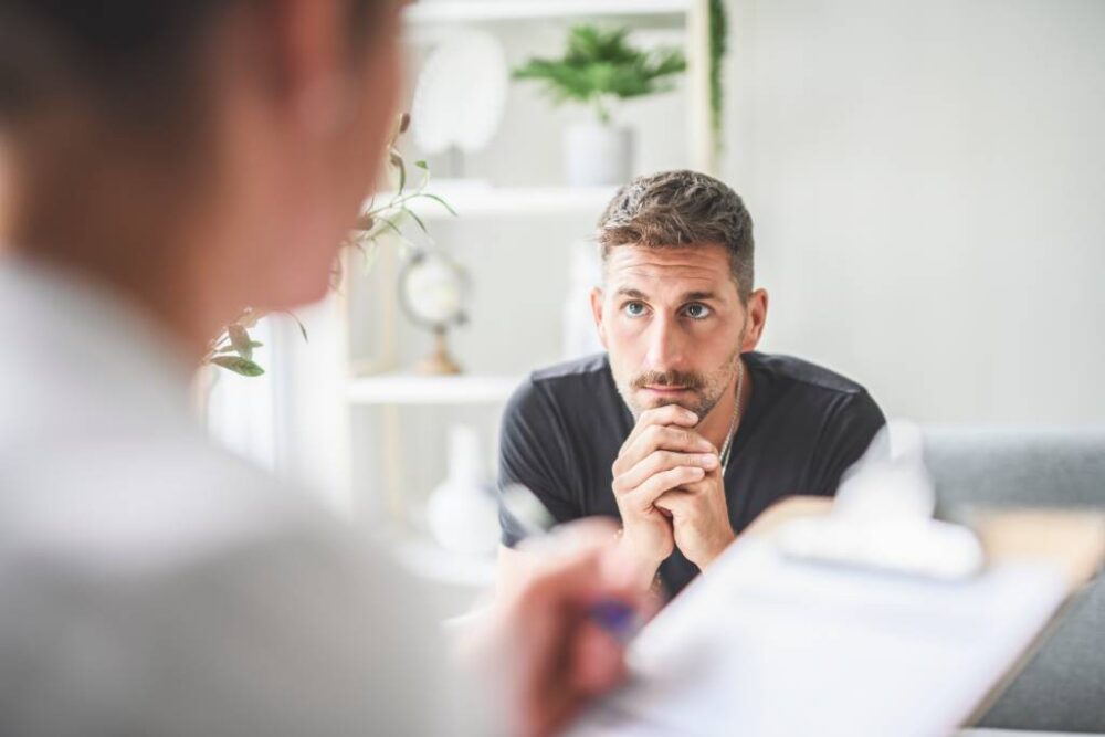 A man listening to a therapist
