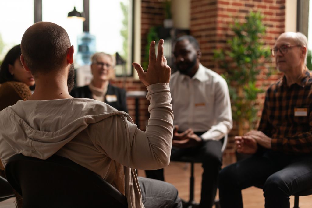 A person raising their hand in a support group