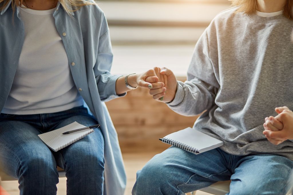 People in group therapy holding hands
