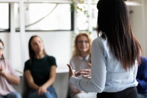 Rearview of a person speaking at group therapy