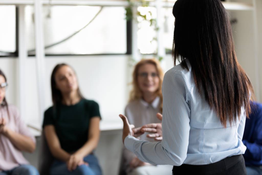 Rearview of a person speaking at group therapy