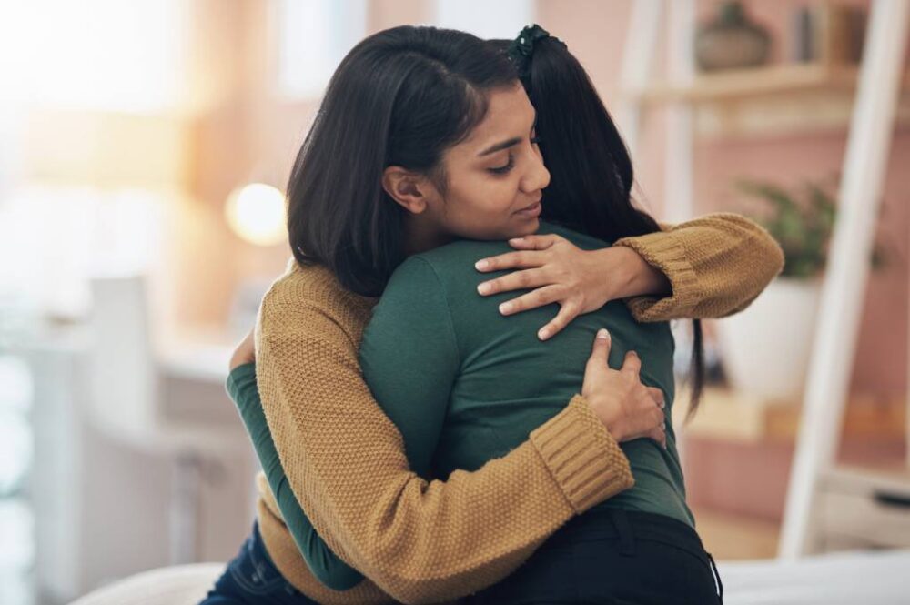 Two women hugging and supporting a loved one in addiction recovery